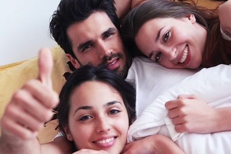 pareja compartiendo cama con chica joven